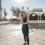 Erin posing outside wearing black Fendi tank top and black leggings and tennis shoes