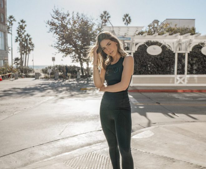 Erin posing outside wearing black Fendi tank top and black leggings and tennis shoes