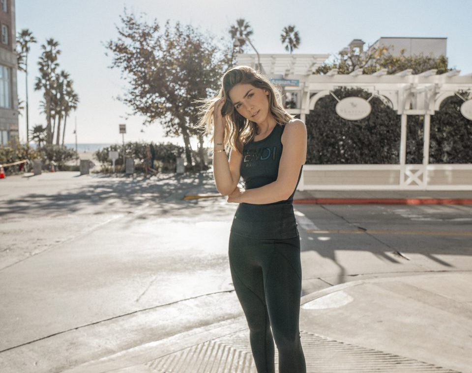 Erin posing outside wearing black Fendi tank top and black leggings and tennis shoes