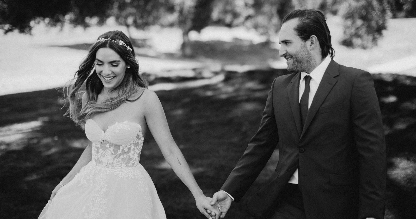 Erin and Matt in their wedding attire smiling and holding hands