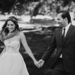 Erin and Matt in their wedding attire smiling and holding hands