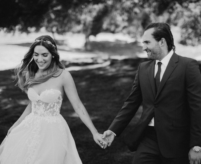 Erin and Matt in their wedding attire smiling and holding hands