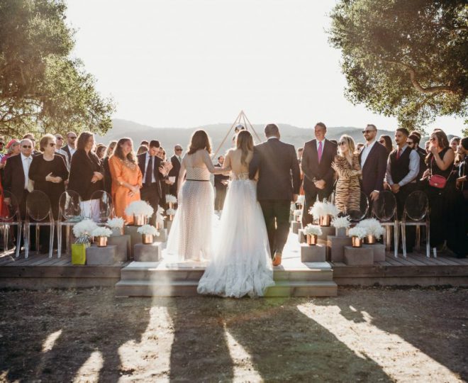 Erin walking up the aisle with her mom and dad on her arm.