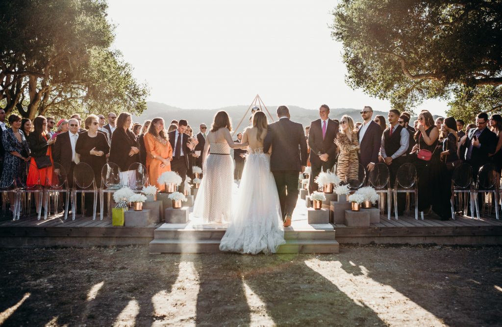 Erin walking up the aisle with her mom and dad on her arm.