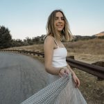 Erin twirling in a flowing tan skirt with black dots and a white Christian Dior tank top.