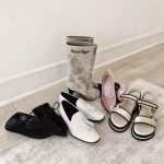 5 pairs of designer shoes arranged on the floor.