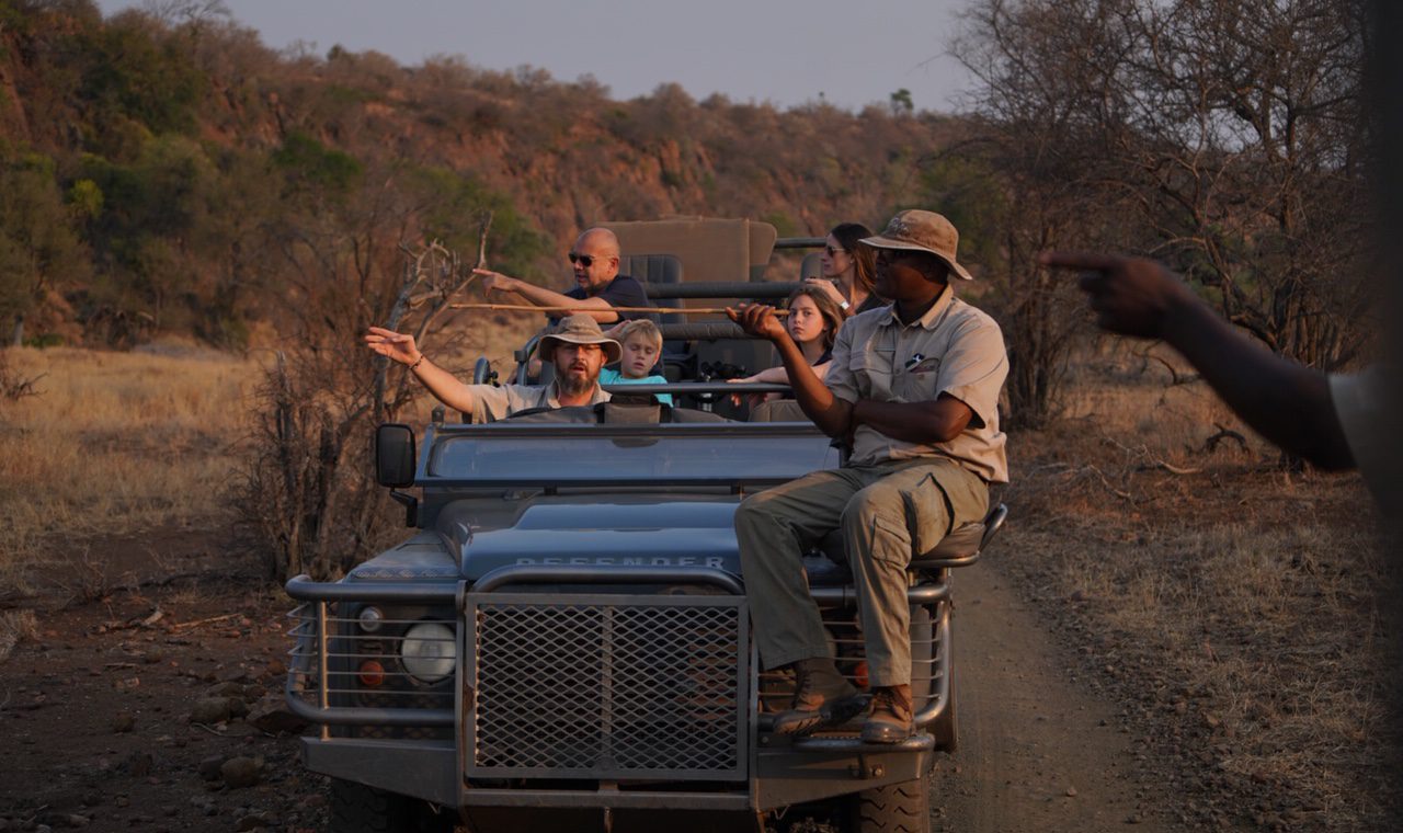 People riding in a jeep in the savanna