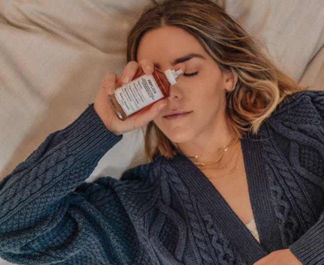 Erin holding a bottle of Maison Margelia By The Fireplace perfume