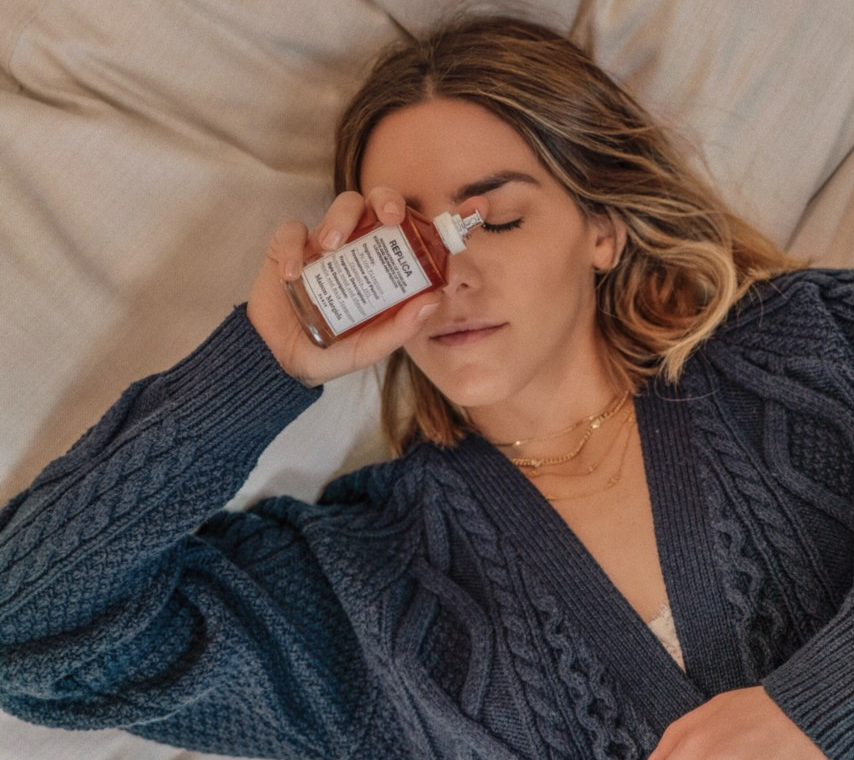 Erin holding a bottle of Maison Margelia By The Fireplace perfume