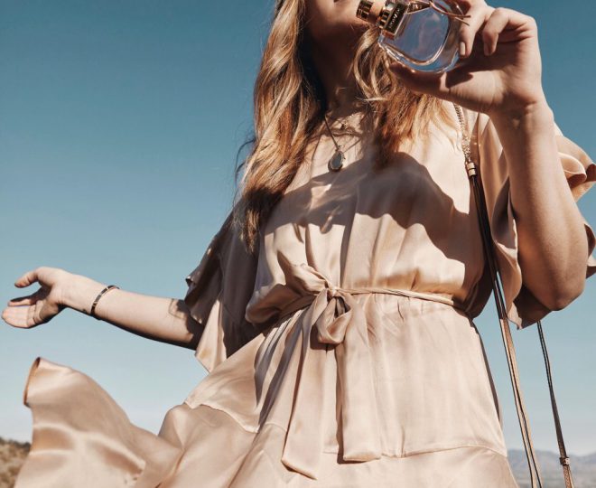 Erin holding a bottle of perfume outside