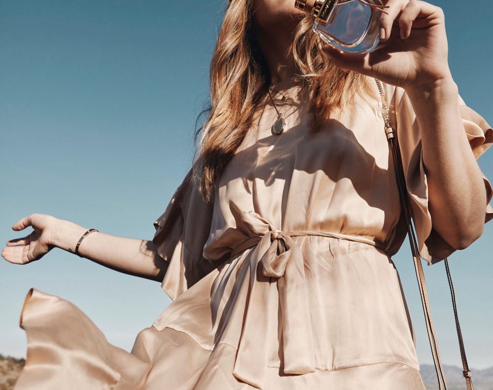 Erin holding a bottle of perfume outside